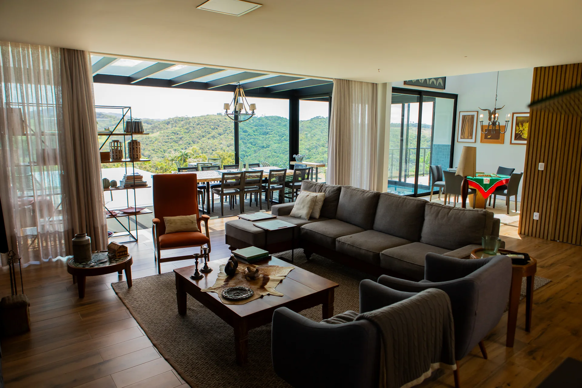 Sala de convivência com grandes aberturas para a paisagem